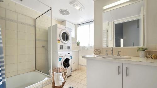 a bathroom with a washing machine and a sink at The Essentials Unit 2 - 1 Marine Parade in Merimbula