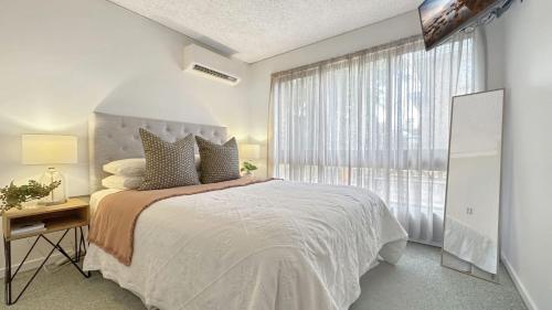 a bedroom with a large bed and a window at The Essentials Unit 2 - 1 Marine Parade in Merimbula