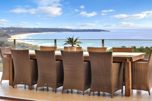 a table and chairs with a view of the ocean at Short Point Quarters - Whole House in Merimbula