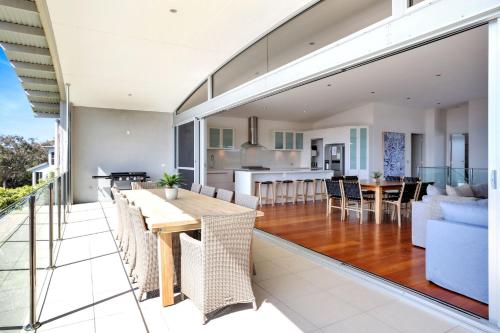 an open living room and kitchen with a table and chairs at Short Point Quarters - Whole House in Merimbula