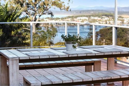 a picnic table on a deck with a view of the ocean at Captains Quarters in Merimbula