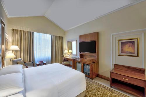 a hotel room with a bed and a flat screen tv at Islamabad Marriott Hotel in Islamabad