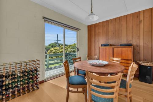 a dining room with a table and chairs and a window at Cliffhanger in Merimbula