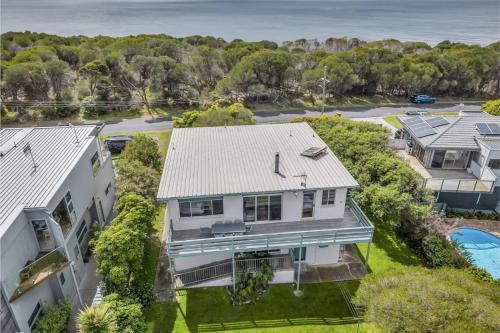an aerial view of a white house with the ocean in the background at Cliffhanger in Merimbula