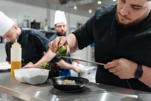 a group of chefs preparing food in a kitchen at Westotel Taverny - Paris Val-d'Oise in Taverny