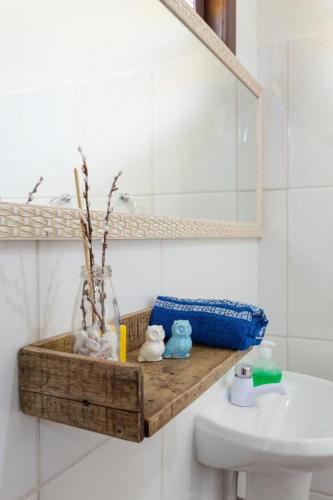 a bathroom with a wooden shelf above a sink at Pousada Dona Elena in Penha