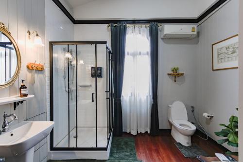 a bathroom with a glass shower and a toilet at DE Phanakron Boutique Hotel in Bangkok