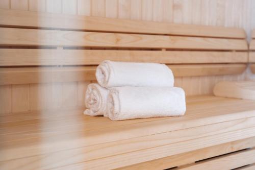 a stack of towels sitting on a shelf in a sauna at Westotel Taverny - Paris Val-d'Oise in Taverny