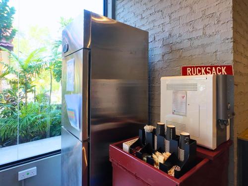 a metal refrigerator next to a brick wall and a window at Rucksack Inn Premium Melaka in Melaka