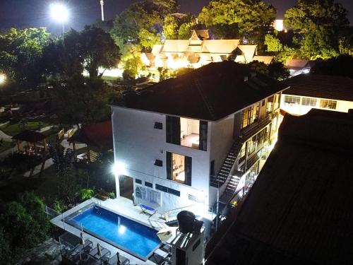 an aerial view of a house at night with a swimming pool at Rucksack Inn Premium Melaka in Melaka