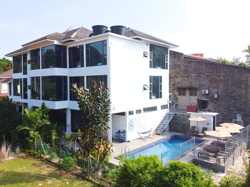a large white house with a swimming pool at Rucksack Inn Premium Melaka in Melaka