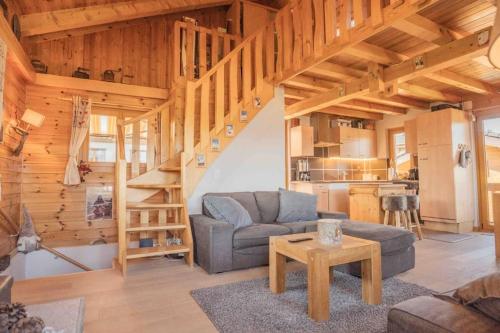 a living room with a couch and a staircase in a house at Chalet avec vue in Nendaz
