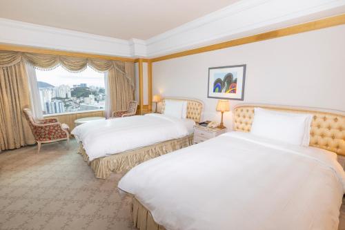 a hotel room with two beds and a window at Lotte Hotel Busan in Busan
