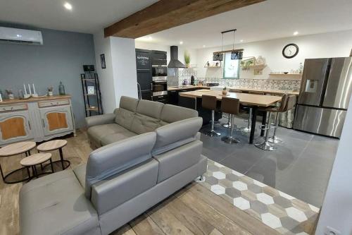 un salon avec un canapé et une cuisine dans l'établissement Maison spacieuses, à Faverolles