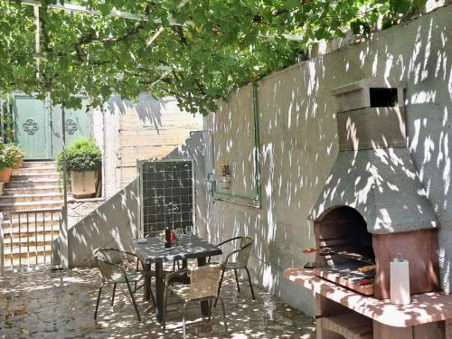 a patio with a table and an outdoor oven at Teta Lidia in Krilo