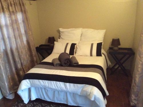 a bed with a person laying on top of it at Klein Paradys Lodge - Polokwane in Polokwane