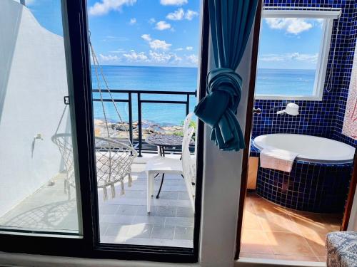 a room with a view of the ocean from a balcony at Rockhand Homestay in Eluan