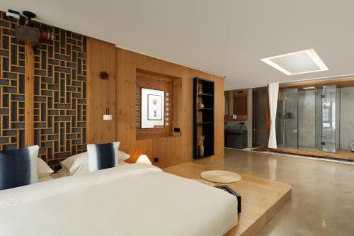 a bedroom with a large bed and a bathroom at 慢境Slow Land半山海景花园酒店 in Dali