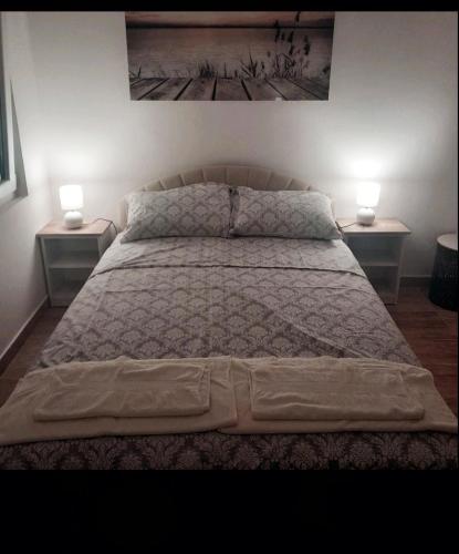 a bedroom with a bed with two lamps on two tables at Lena in Meljine