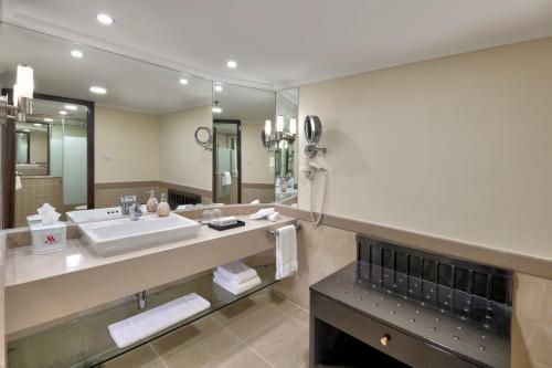 a bathroom with a sink and a large mirror at Islamabad Marriott Hotel in Islamabad