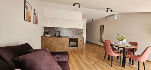 a living room with a couch and a table with chairs at Arkady House in Olsztynek