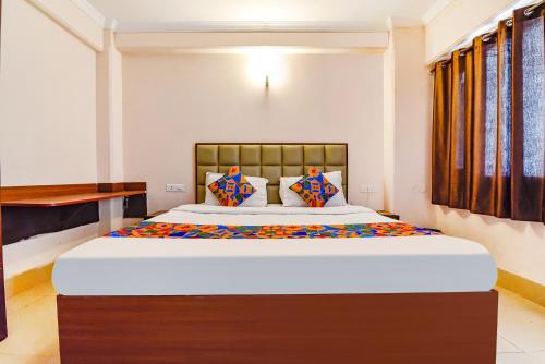 a bedroom with a large bed in a room at FabExpress Central Plaza in Dehradun