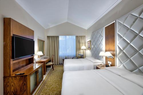 a hotel room with two beds and a flat screen tv at Islamabad Marriott Hotel in Islamabad