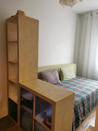 une petite chambre avec un lit et une armoire dans l'établissement Appartement 35 m2 Paris Malakoff, à Malakoff