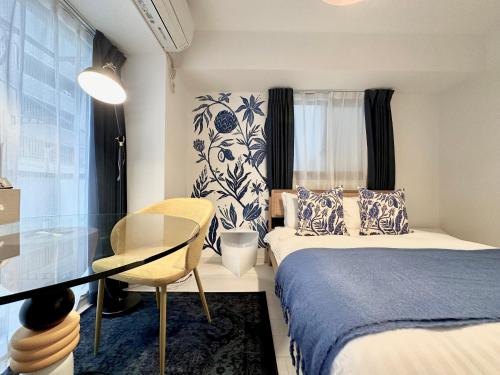 a bedroom with two beds and a table and a chair at LANG Hotel GINZA 1K in Tokyo