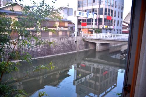 a view of a river with buildings and a bridge at Hostelコトヒラクラスカ in Kotohira