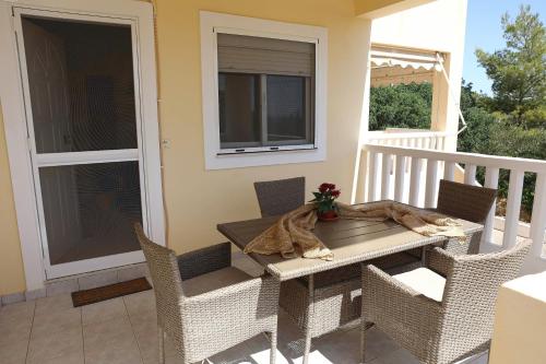a porch with a table and chairs on a balcony at Sun Arise in Porto Rafti