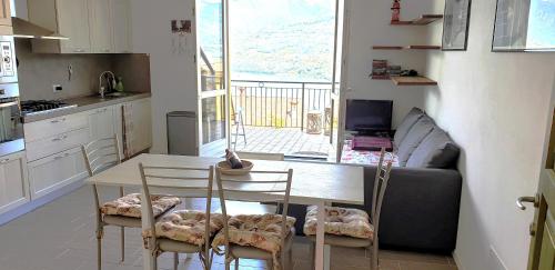 una cucina con tavolo, sedie e un divano di Die Sonnenterrasse vom Iseosee a Tavernola Bergamasca