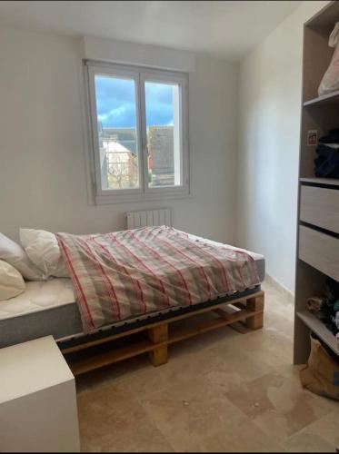 une chambre avec un lit et une fenêtre dans l'établissement Appart 2 min de la plage, à Benerville-sur-Mer