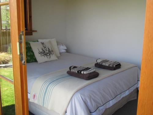 1 dormitorio con 1 cama con toallas en Behind the Bike Sheds en Waipiata