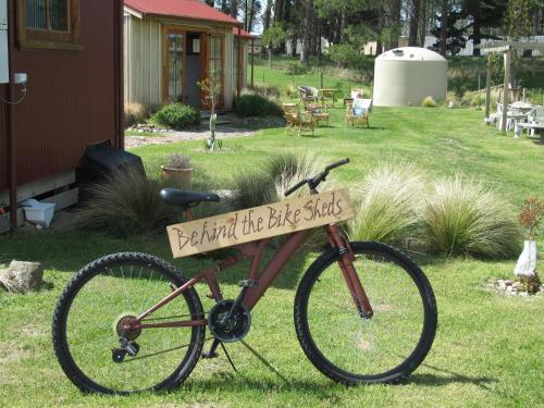 uma bicicleta com um sinal na relva em Behind the Bike Sheds em Waipiata