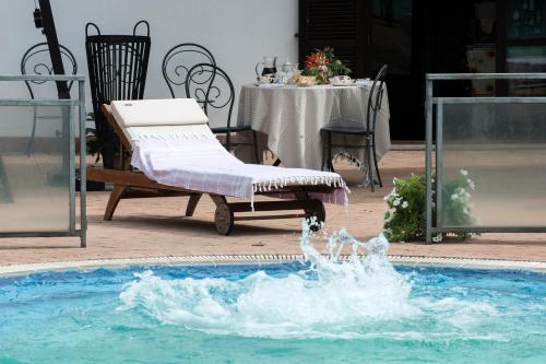 a swimming pool with a chair and a table with a table at Tenuta Colle Mattia in Colonna