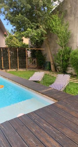 une paire de chaises assises à côté de la piscine dans l'établissement Le nid kalain, à Bourg-lès-Valence