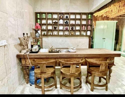 a kitchen with a large wooden table and chairs at Lavender star house in Kuta