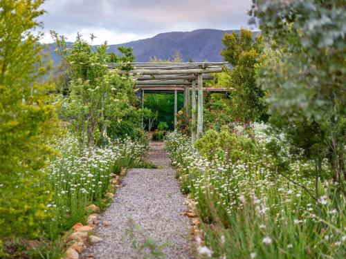 a path through a garden with a wooden pergola at Galloway Guest House in Robertson
