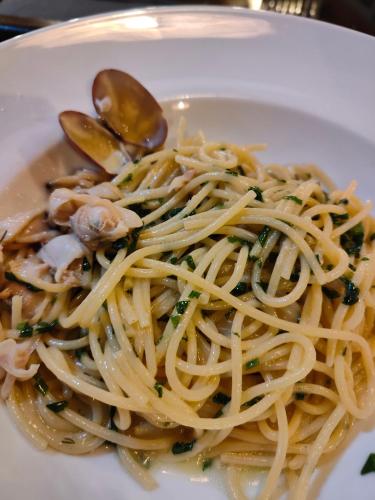 a white plate of pasta with mushrooms and greens at Agorastos Luxury Living in Platamonas