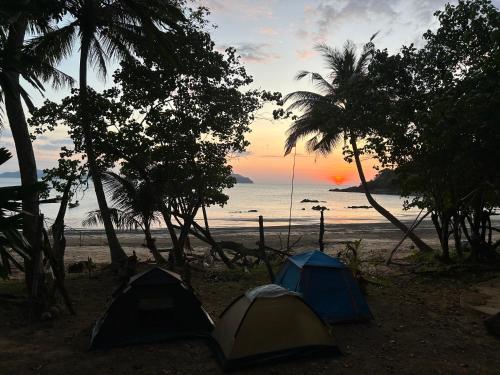 two tents on the beach with the sunset in the background at Eternal Forest Beach Bar&Bungalow in Koh Chang Ranong