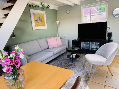 a living room with a couch and a tv at Balsemientexel in De Koog