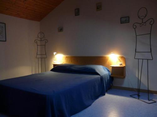 a bedroom with a bed and two mannequins on the wall at Les boulites in Roches-Prémarie-Andillé