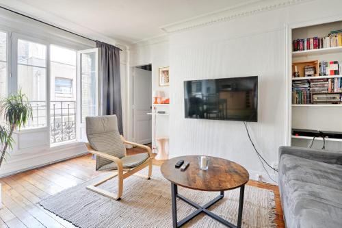 un salon avec un canapé et une table dans l'établissement Appartement Lucent - Welkeys, à Paris