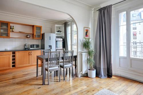 une cuisine et une salle à manger avec une table et des chaises dans l'établissement Appartement Lucent - Welkeys, à Paris
