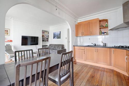 une cuisine et une salle à manger avec une table et des chaises dans l'établissement Appartement Lucent - Welkeys, à Paris