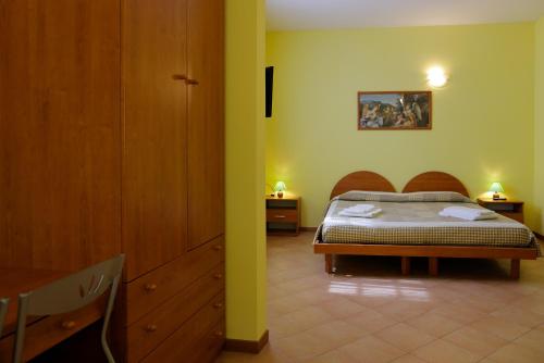 a bedroom with a bed and two night stands and a table at Agriturismo Villa Guarnaschelli in Scandicci