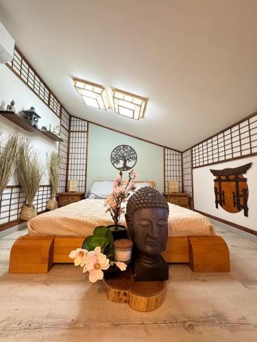 - une chambre avec un lit doté d'une statue de tête dans l'établissement Les Chambres de Paulette a thème LA ZEN, à Sainte-Marie-la-Mer