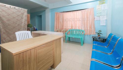 a hospital room with a desk and two chairs at CM Apartelle Iloilo International Airport by RedDoorz in Cabatuan