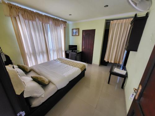 a bedroom with a bed and a desk and a window at The Paradise by Prasanth in Munnar
